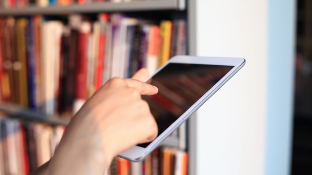 Symbolbild User mit Tablet in einer Bücherei