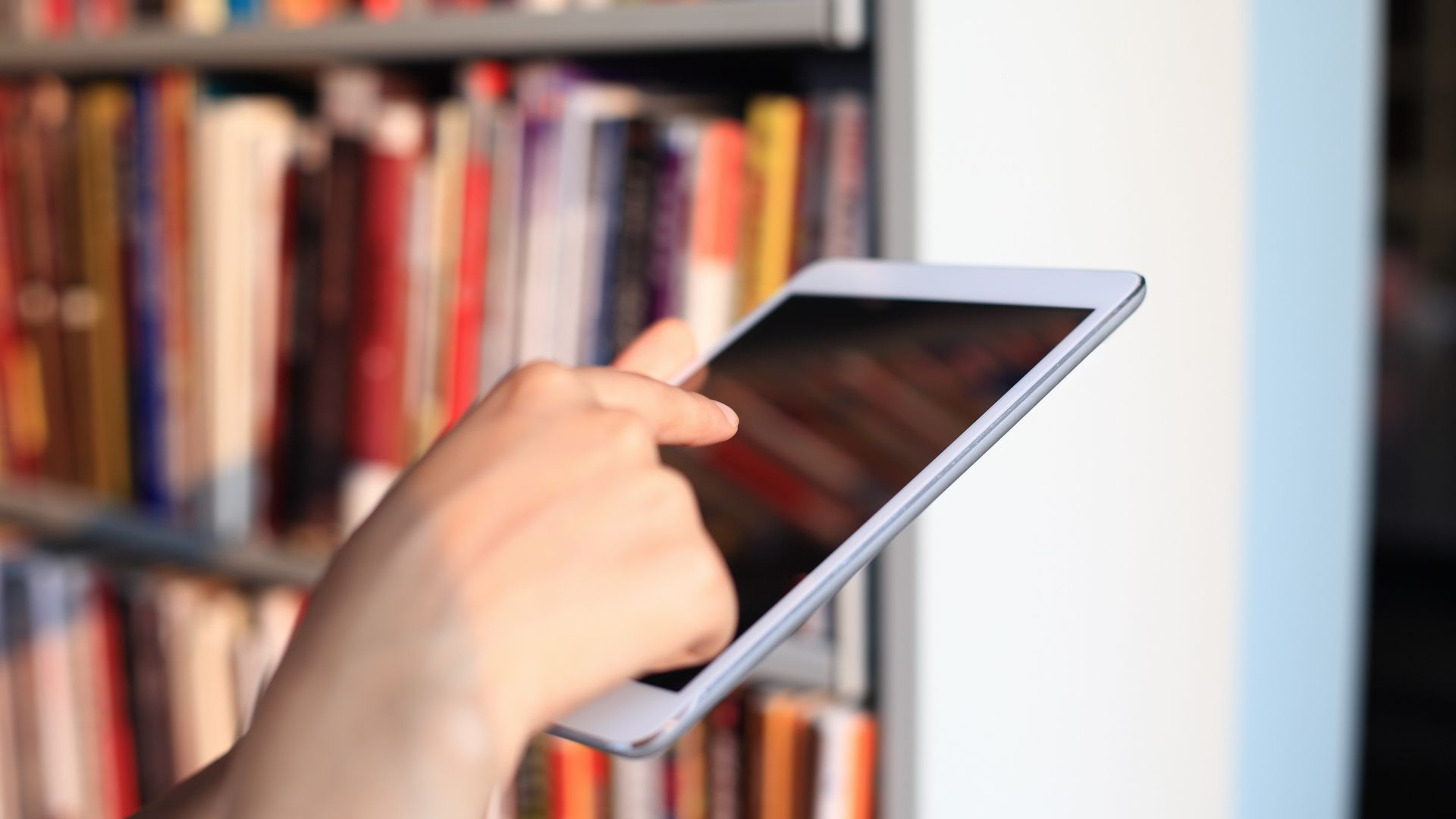 Symbolbild User mit Tablet in einer Bücherei