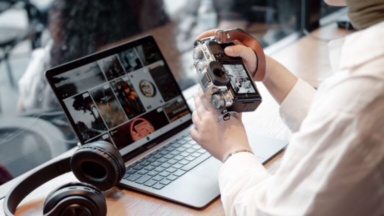 Notbook mit Bildern, davor ein Mensch mit Kamera