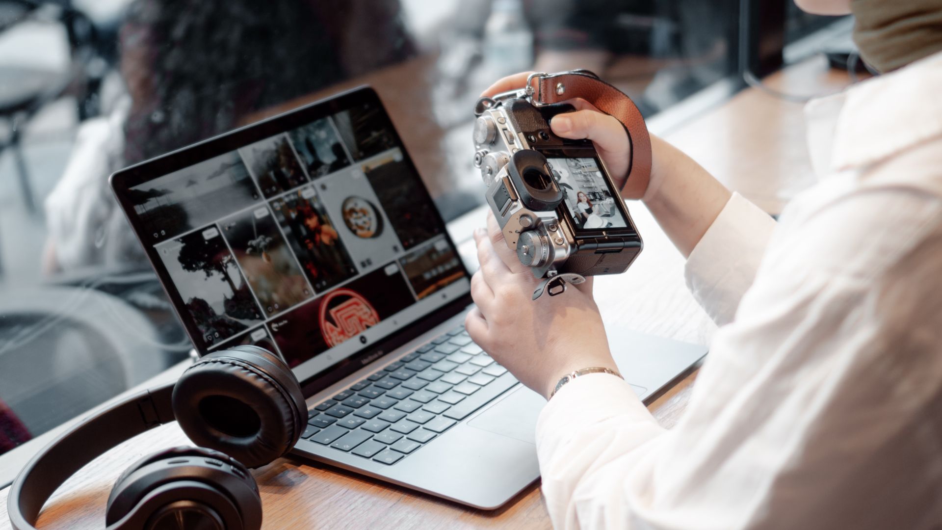 Notbook mit Bildern, davor ein Mensch mit Kamera