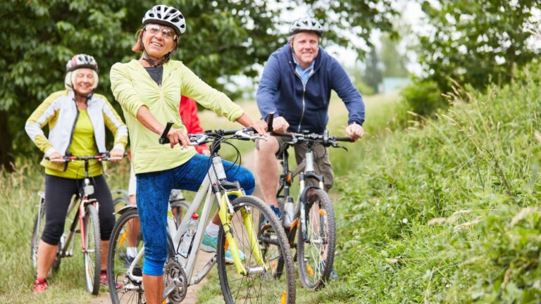 Eine Gruppe von Radfahrern auf E-Bikes planen mit Bikemap App ihre nächste Radtour