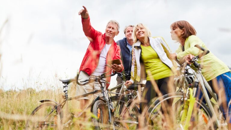 Radfahrer auf E-Bikes vergleicht Fahrrad-Apps auf dem Smartphone vor der Tour