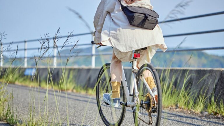 Frau auf E-Bike nutzt Komoot App für die Navigation auf einer Radtour