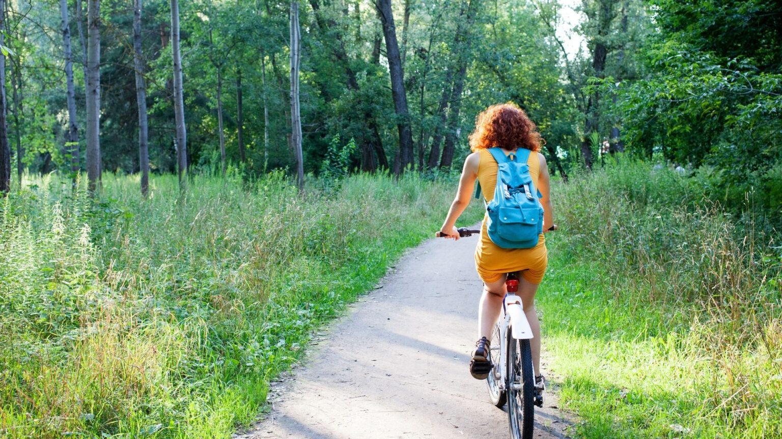 Frau auf E-Bike checkt ihre Strava Statistiken nach einer Radtour