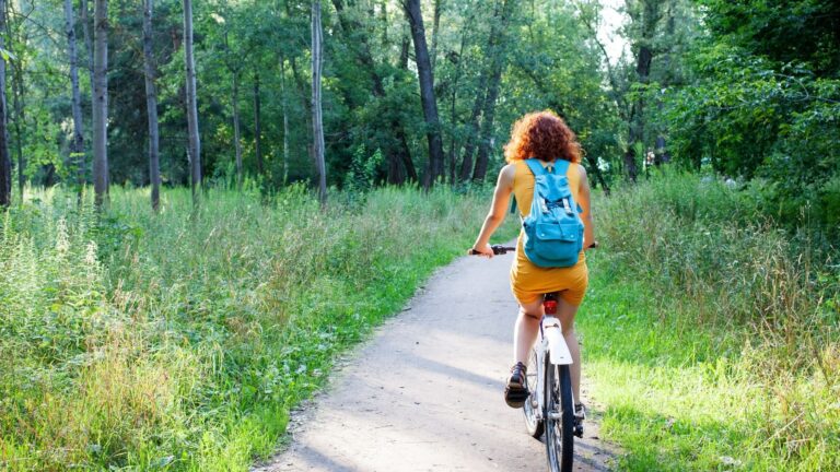 Frau auf E-Bike checkt ihre Strava Statistiken nach einer Radtour