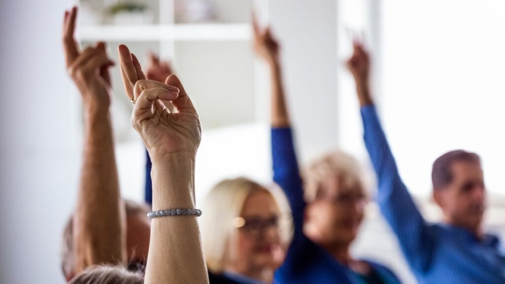 Personen in einem Meeting beim Abstimmen