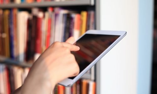 Bücherei Symbolbild User mit Tablet in einer Bücherei