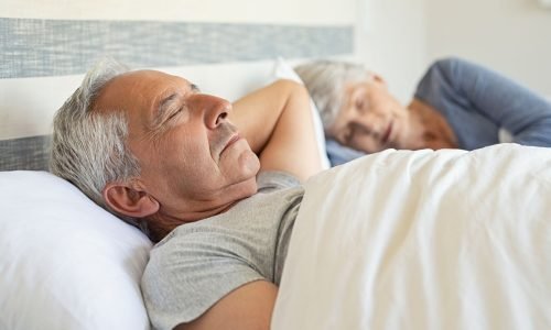 schlafen Ein Mann liegt im Bett und schläft